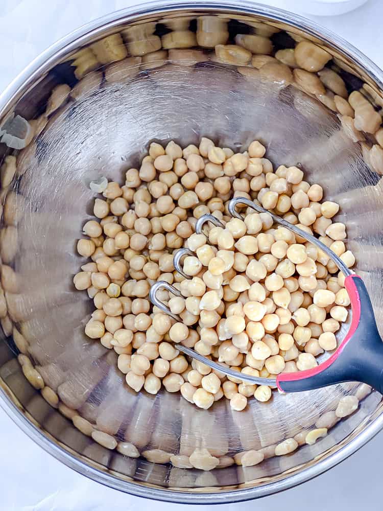 process shot of adding chickpeas to bowl