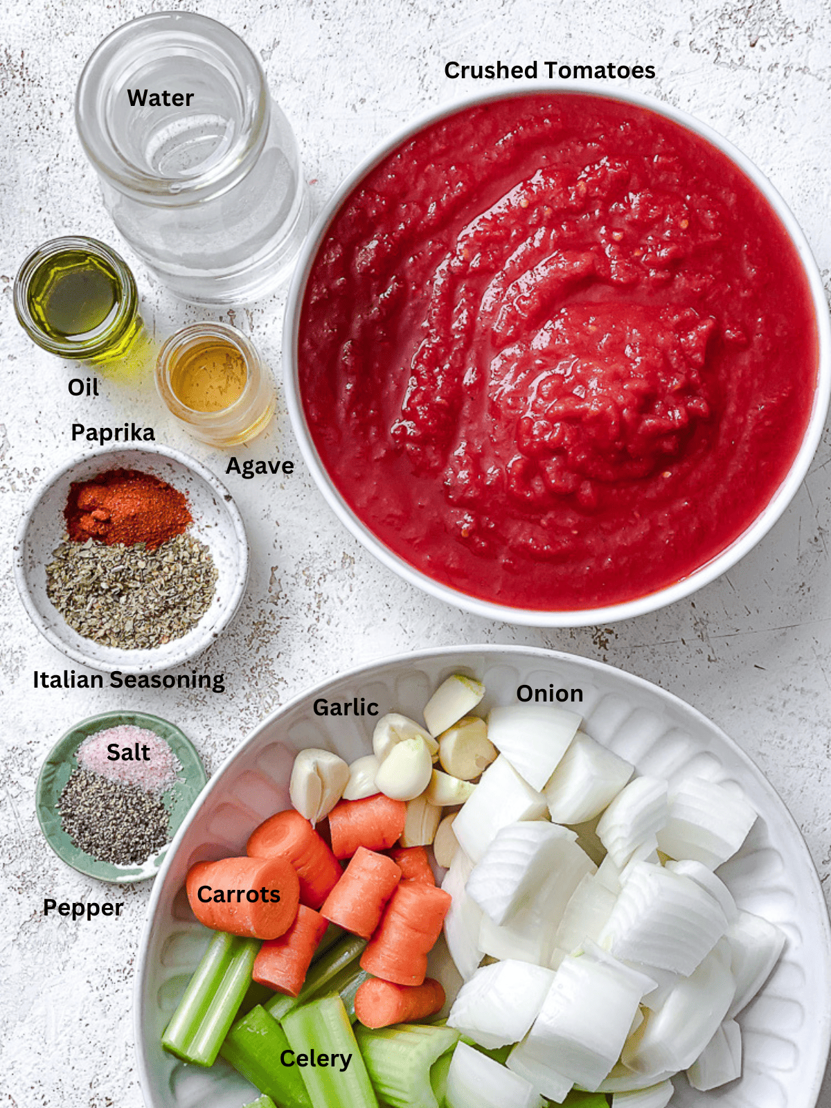 ingredients for Vegan Spaghetti Sauce measured out on a white surface