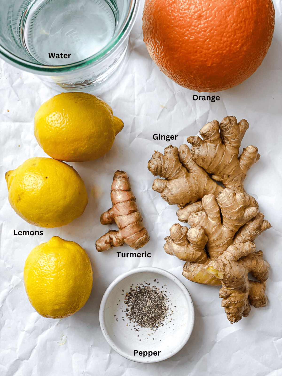 ingredients for Lemon Ginger Turmeric Shots on a white surface