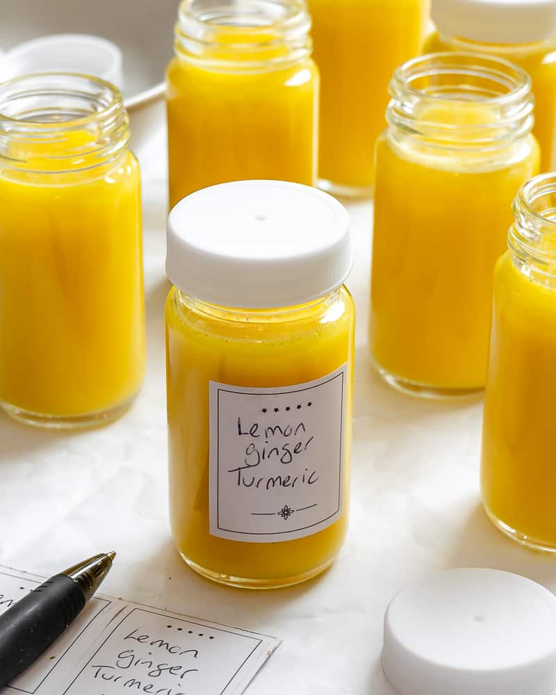 several containers of Lemon Ginger Turmeric Shots on a white surface