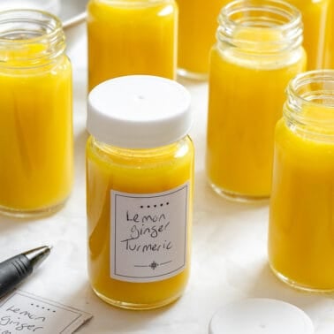 several containers of Lemon Ginger Turmeric Shots on a white surface