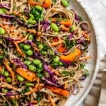 close up on soba noodle salad on a large white serving plate.