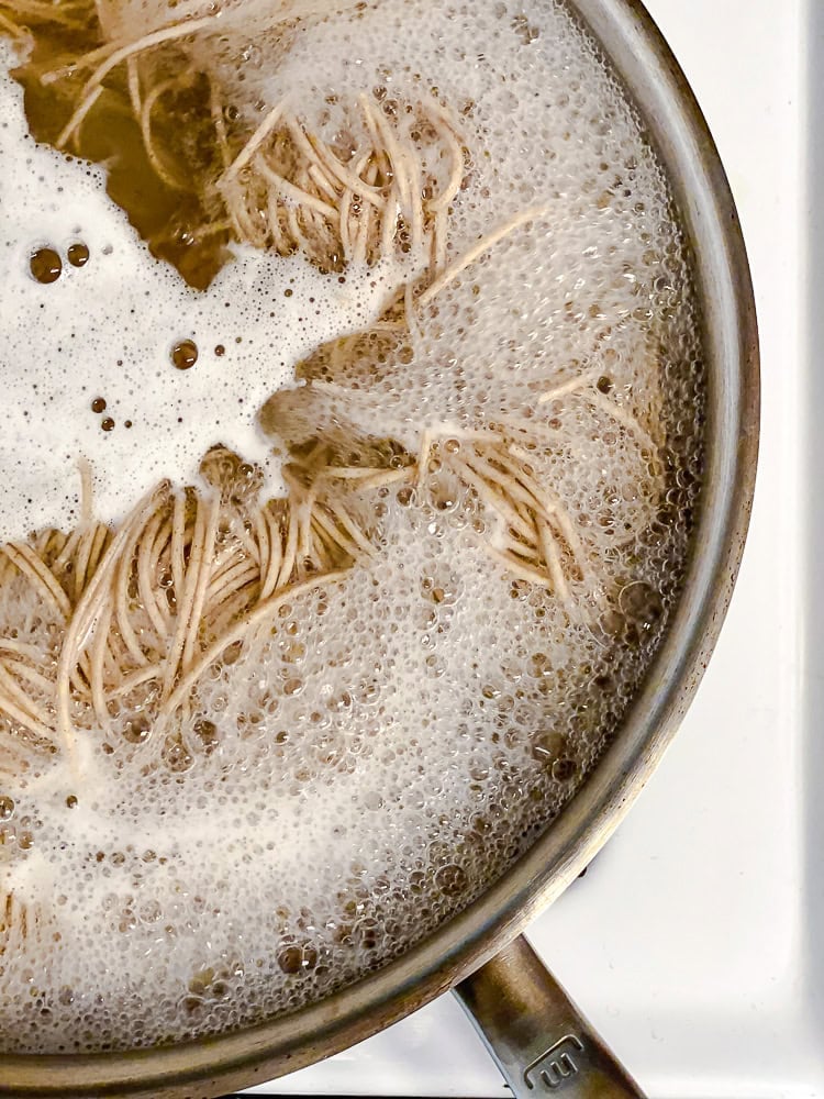 Process shot showing noodles in pot.