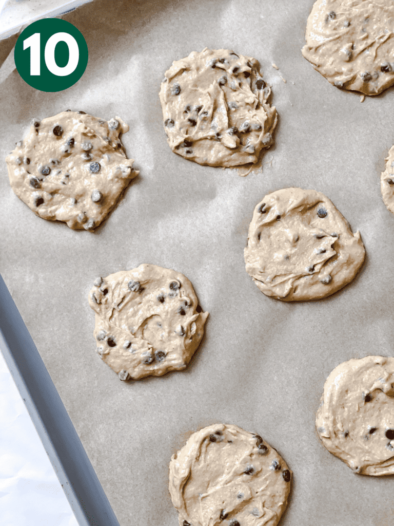 process shot showing flattening the cookies on a baking sheet