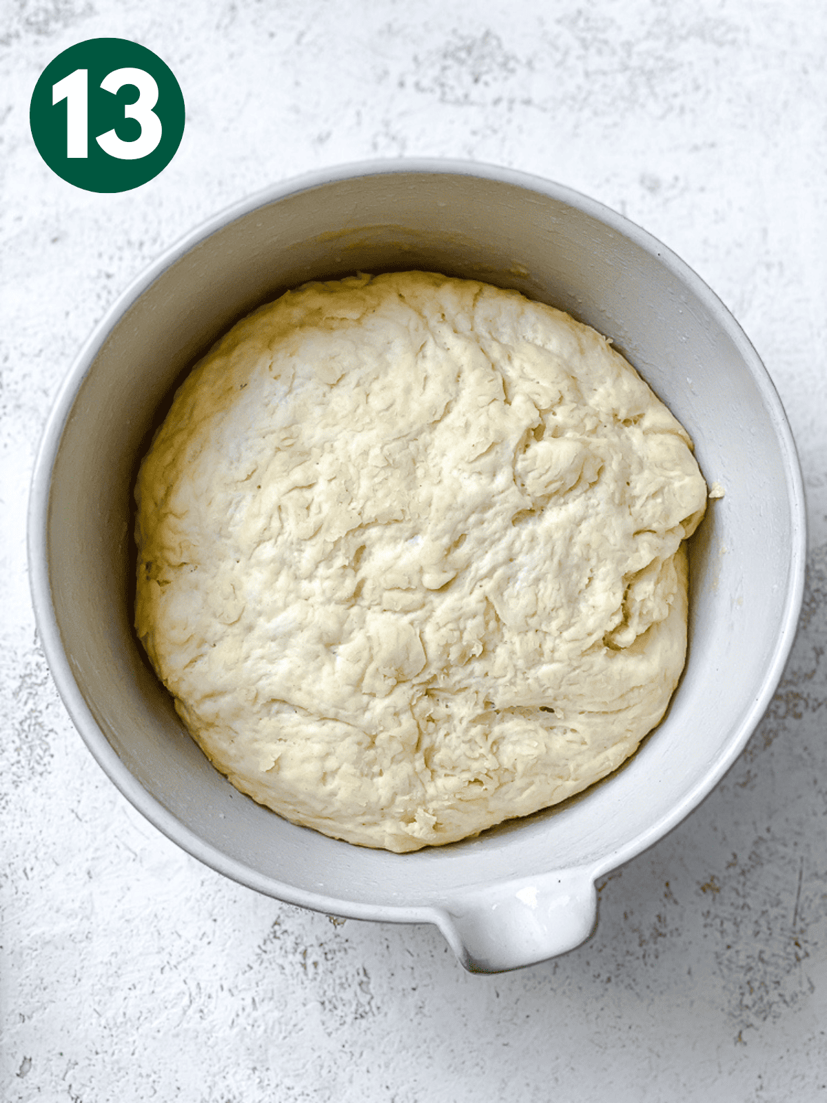 risen dough in a large white bowl.