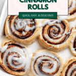 pinterest image of vegan cinnamon rolls with icing on top in a baking dish.