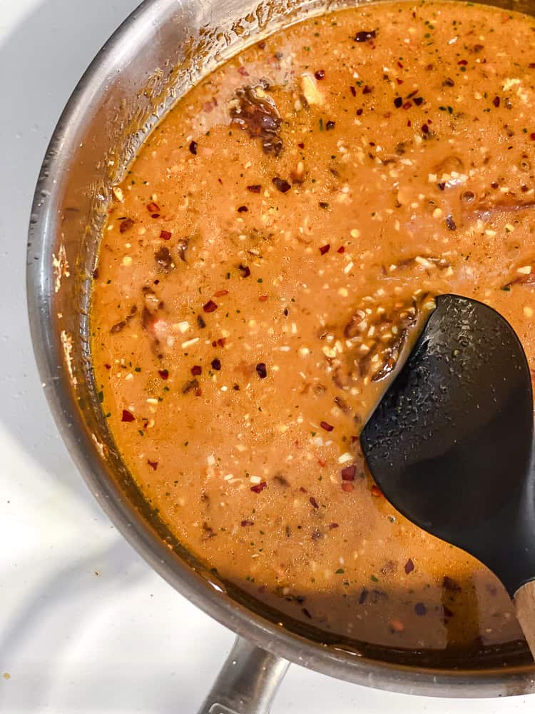 Sauce being stirred in the pan as it thickens