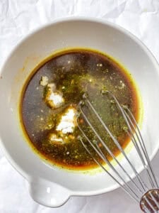 Sauce ingredients in a white bowl with a whisk