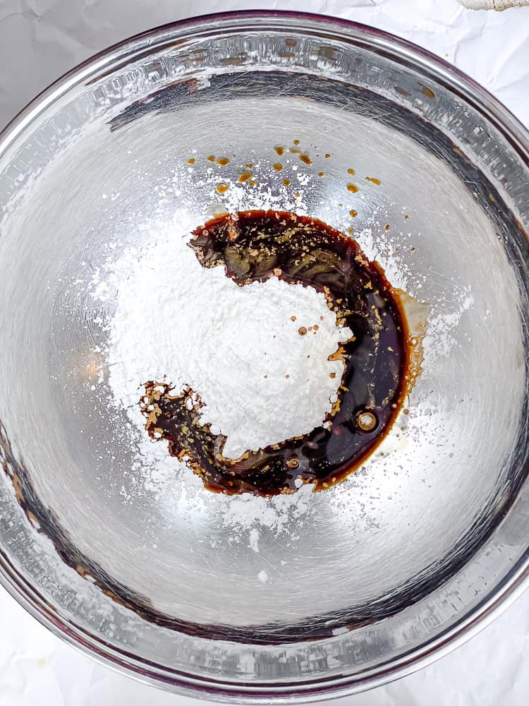 Cornstarch and soy sauce in a large metal bowl