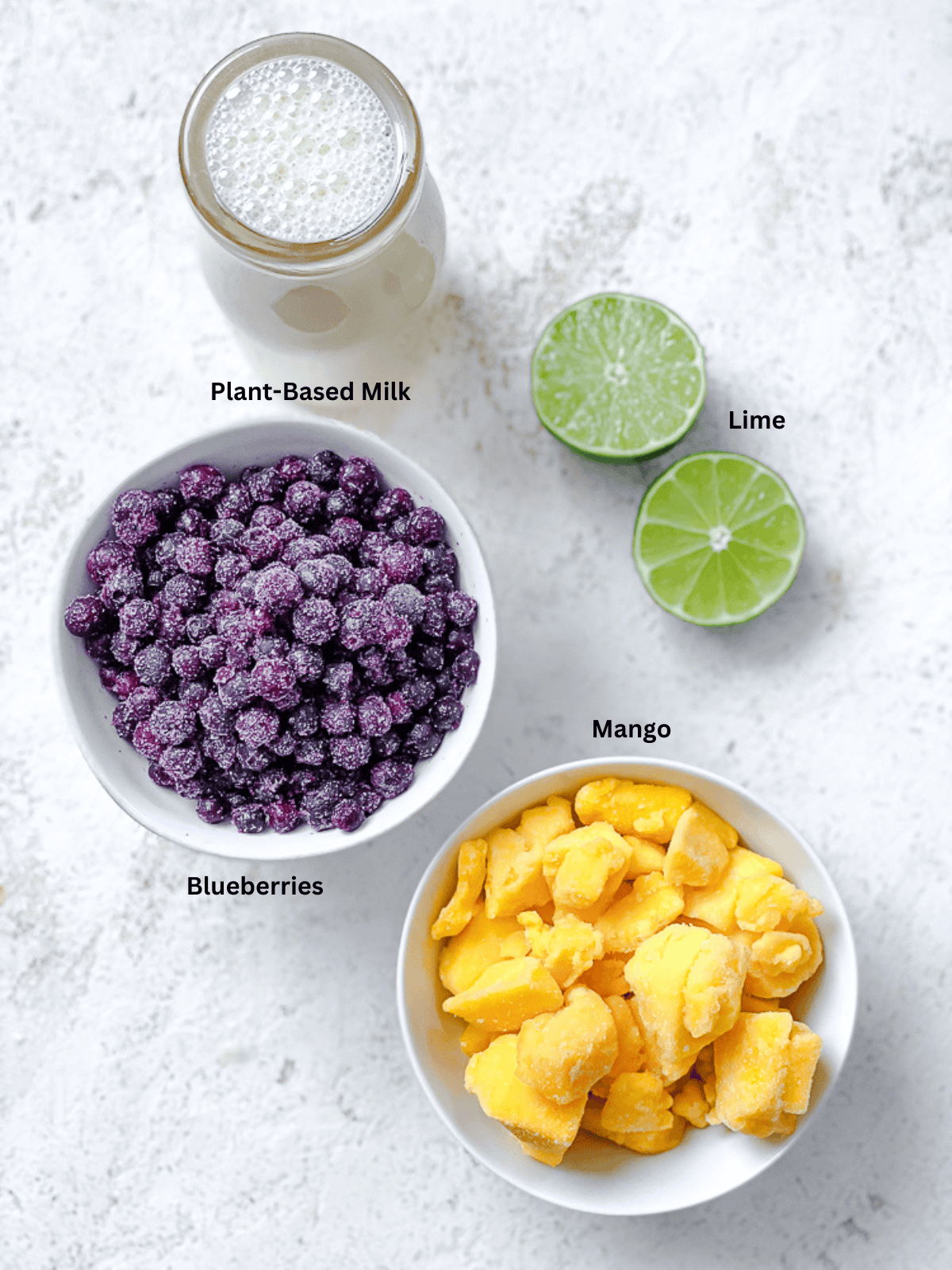 ingredients for Mango Blueberry Smoothie measured out on a white surface