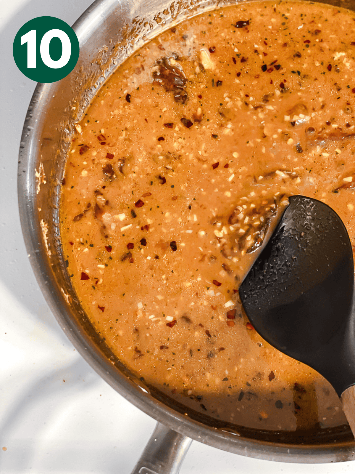 stirring General Tso's sauce in a large metal pan.