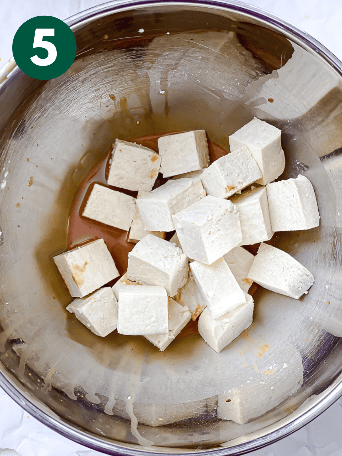 tossing tofu cubes in a soy sauce-cornstarch mixture.