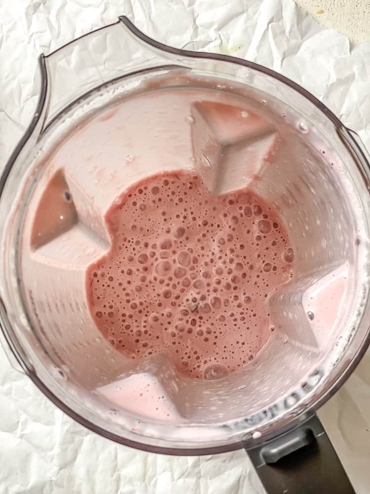 Process shot showing post blended strawberry milk in blender.