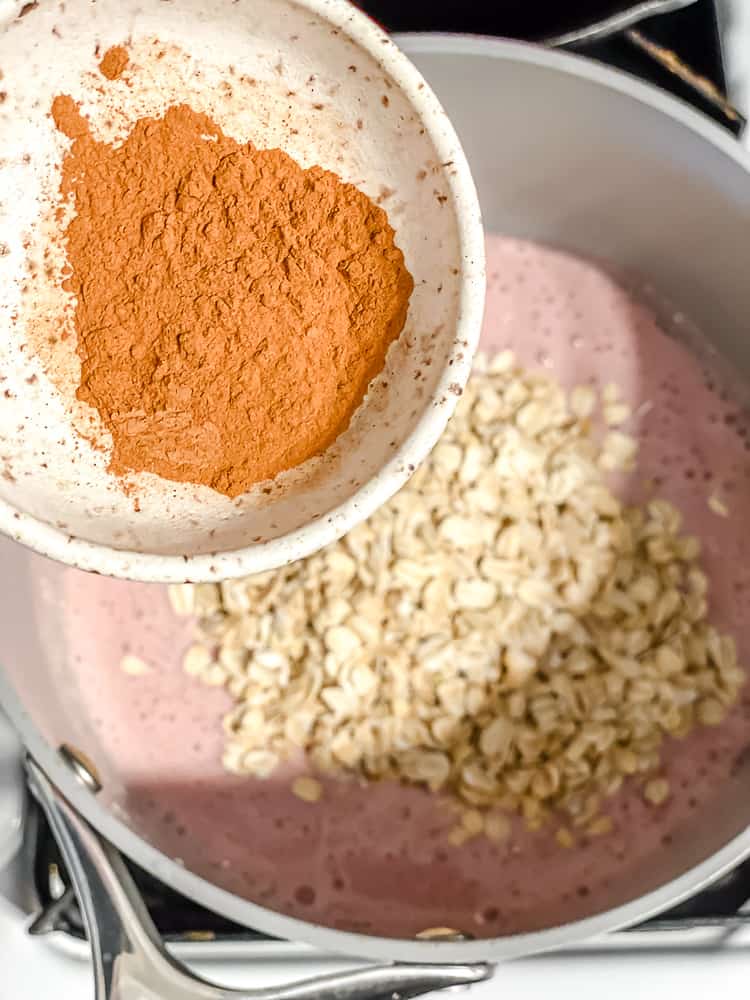 Process shot showing cinnamon being added to pot.