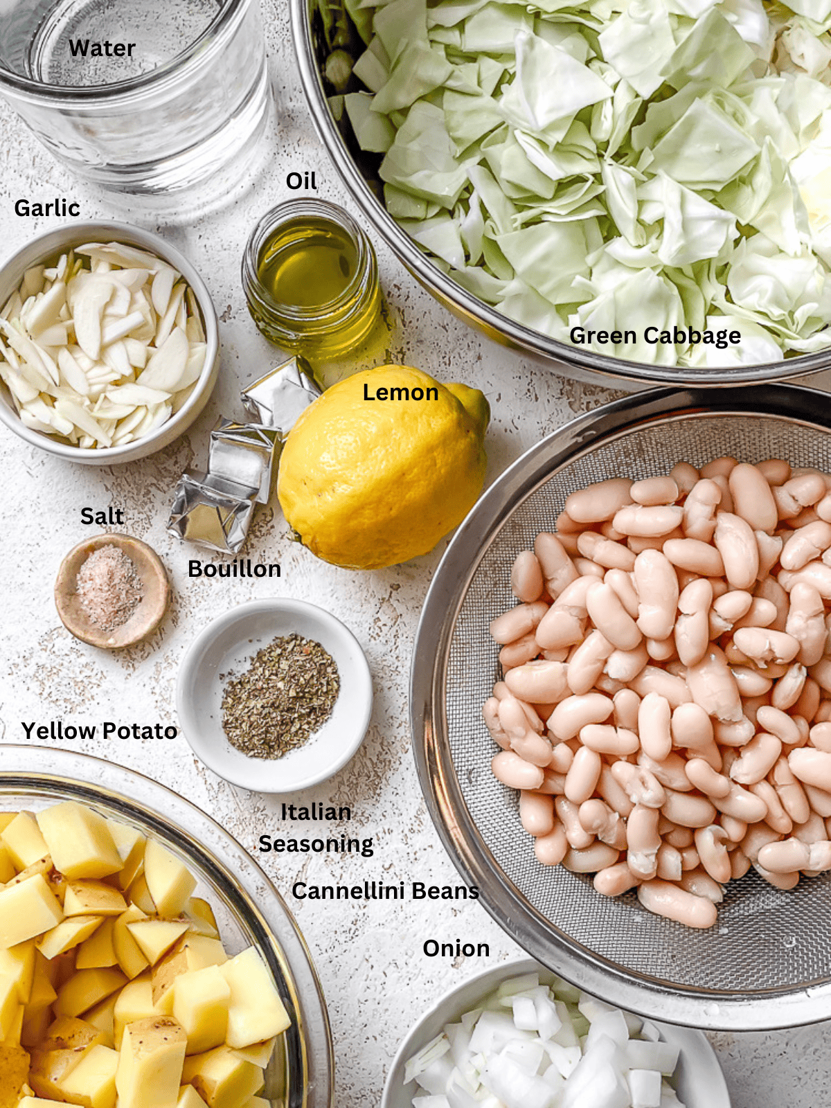 ingredients for Cabbage Bean Soup measured out on a white surface