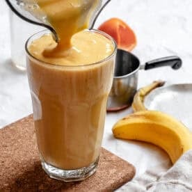 completed Mango Orange Smoothie being poured into a cup