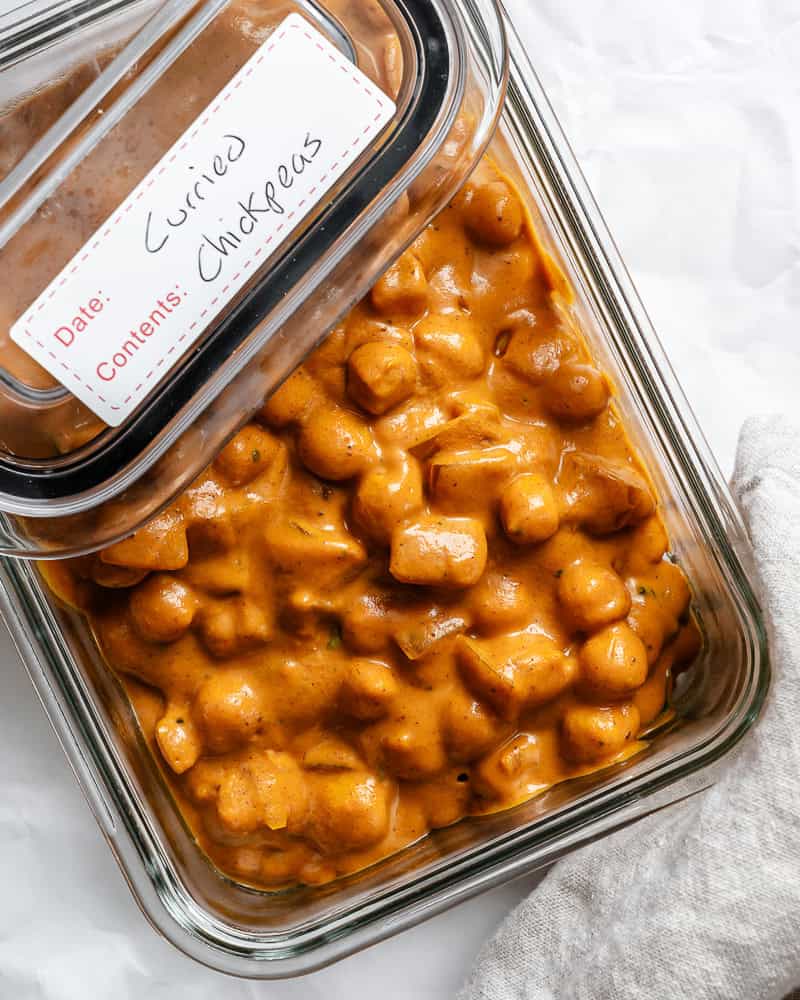 curried chickpeas in a glass storage container.