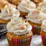 completed Vegan Funfetti Cupcakes on a white surface and cupcake tin