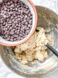 process shot showing chocolate chips being added to bowl