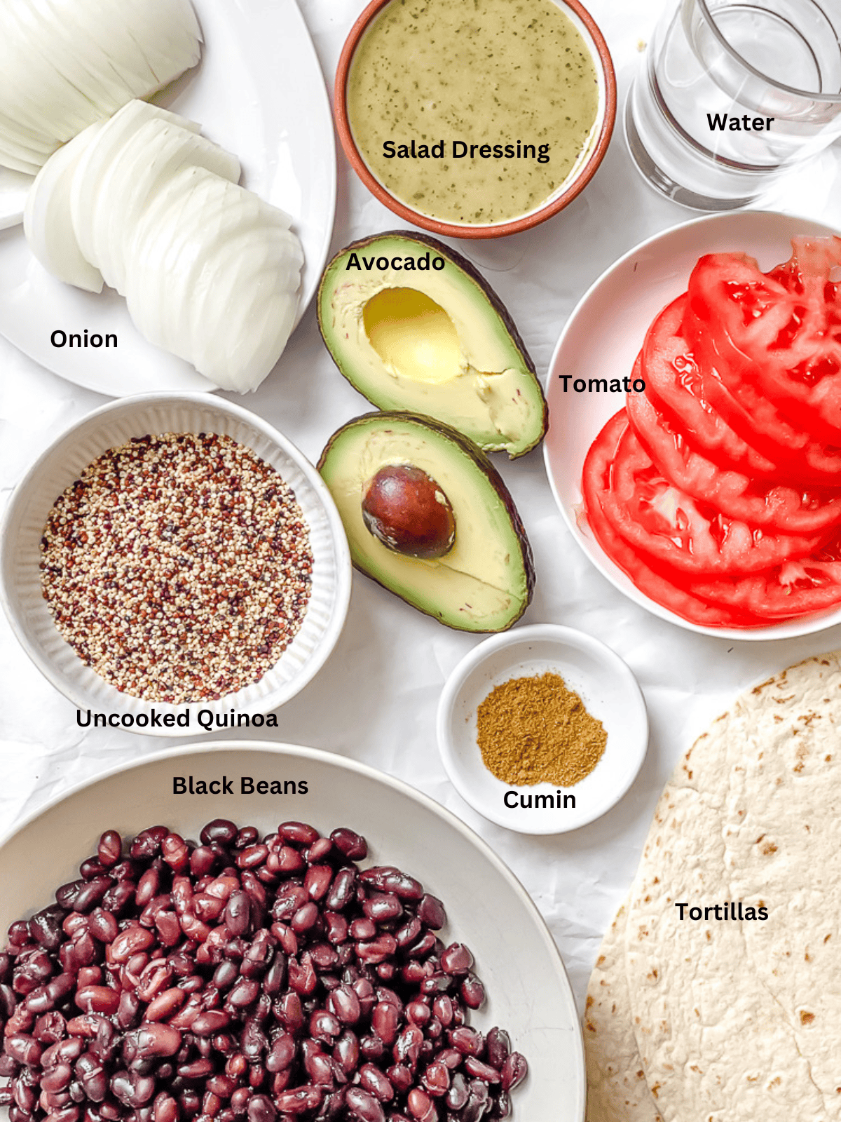 ingredients for Quinoa Black Bean Burritos measured out on a white surface