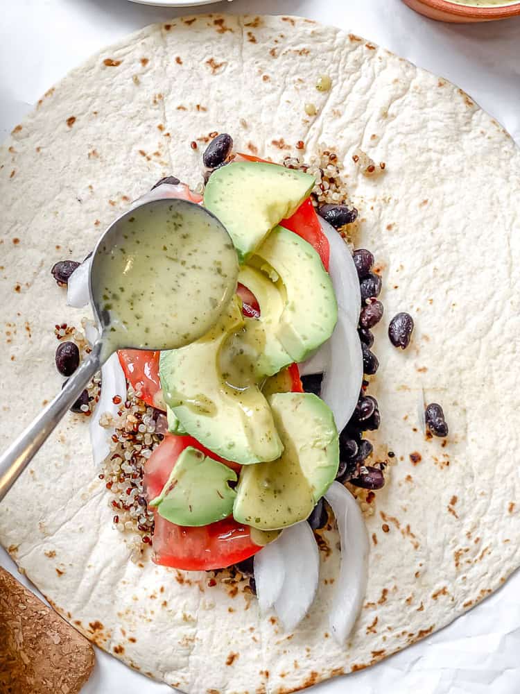 process shot showing adding salad dressing to burrito