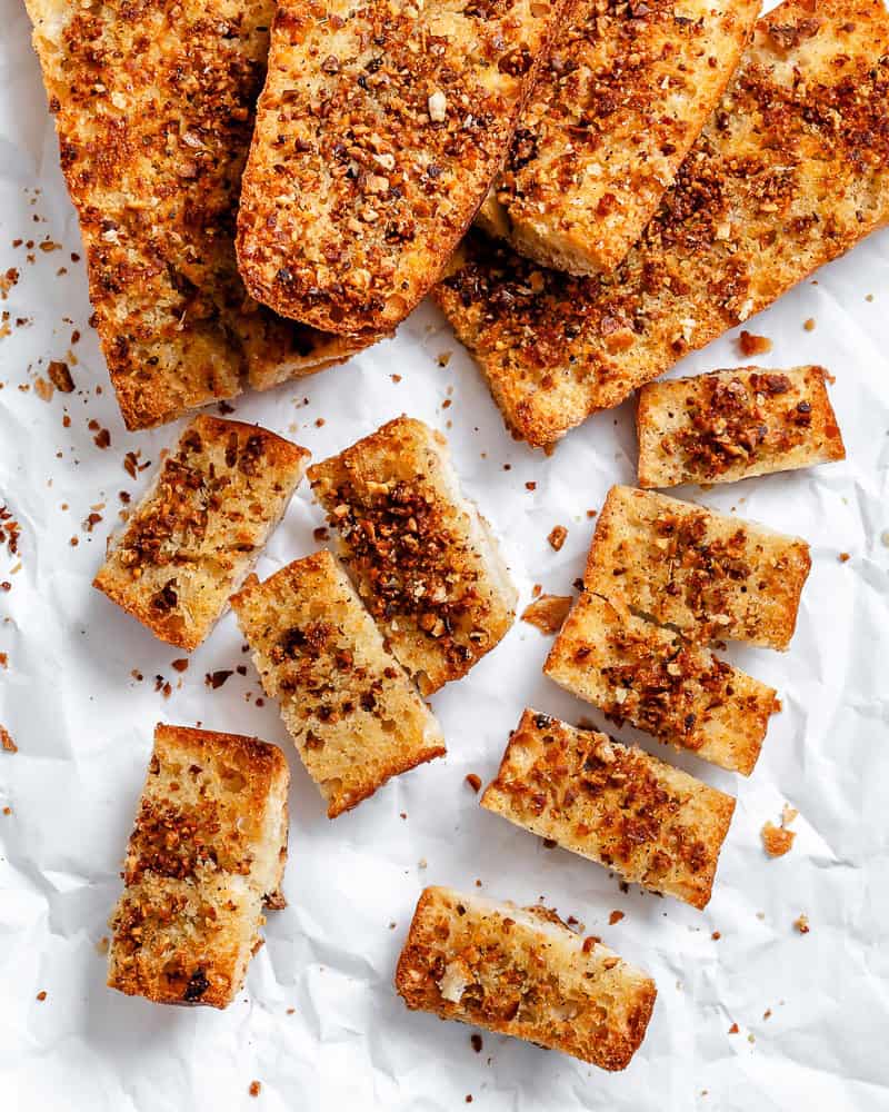 several Easy Vegan Garlic Bread pieces on white surface
