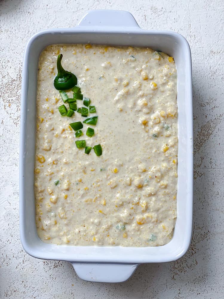 uncooked jalapeno cornbread batter in a white baking dish.