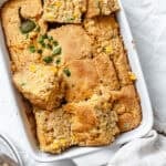 slices of baked jalapeno cornbread in a white baking dish.