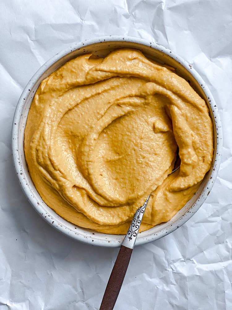 blended sweet potato hummus in a white bowl.