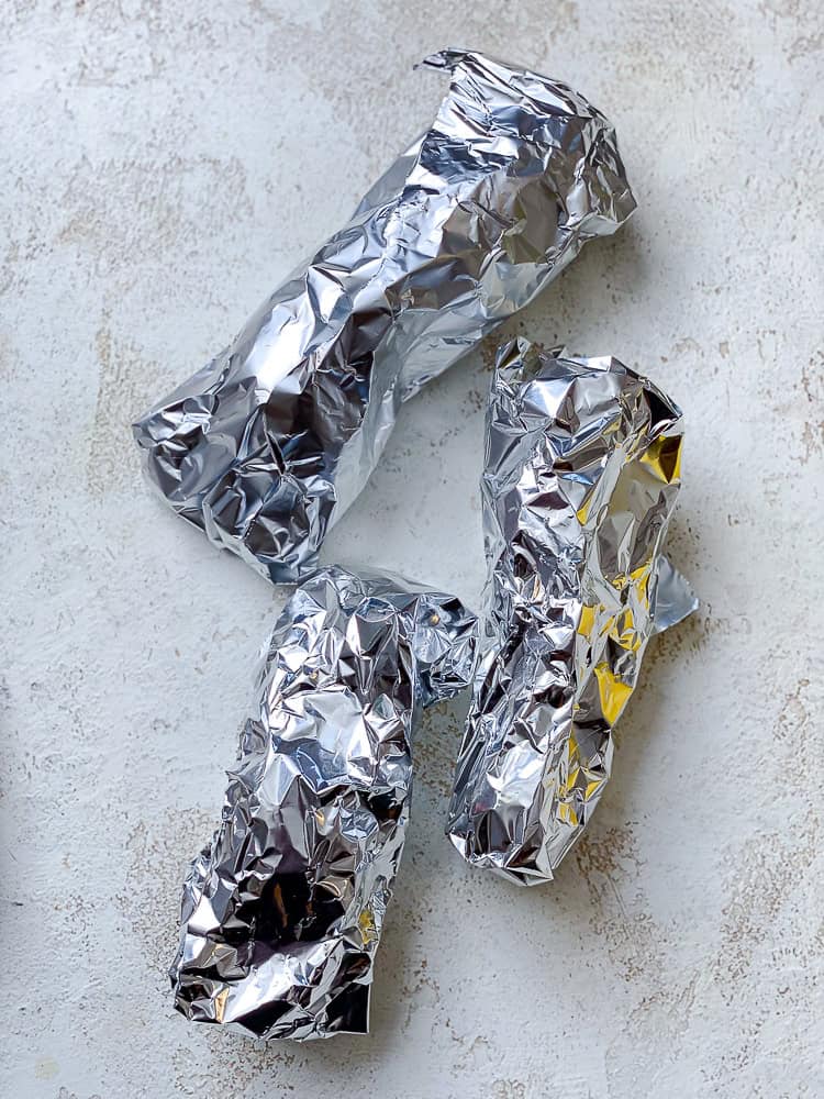 3 sweet potatoes wrapped in foil.