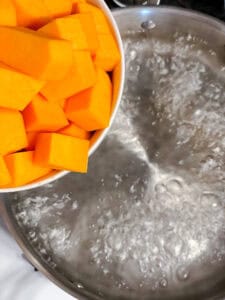 process shot showing adding butternut squash to pot
