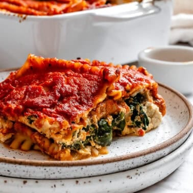 a piece of vegan lasagna on a white plate.