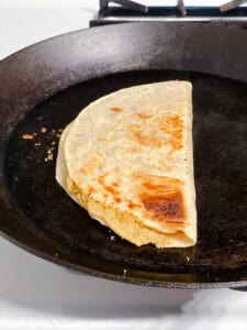 a vegan bean quesadilla in a black skillet.