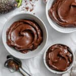 3 white bowls of chocolate avocado mousse.