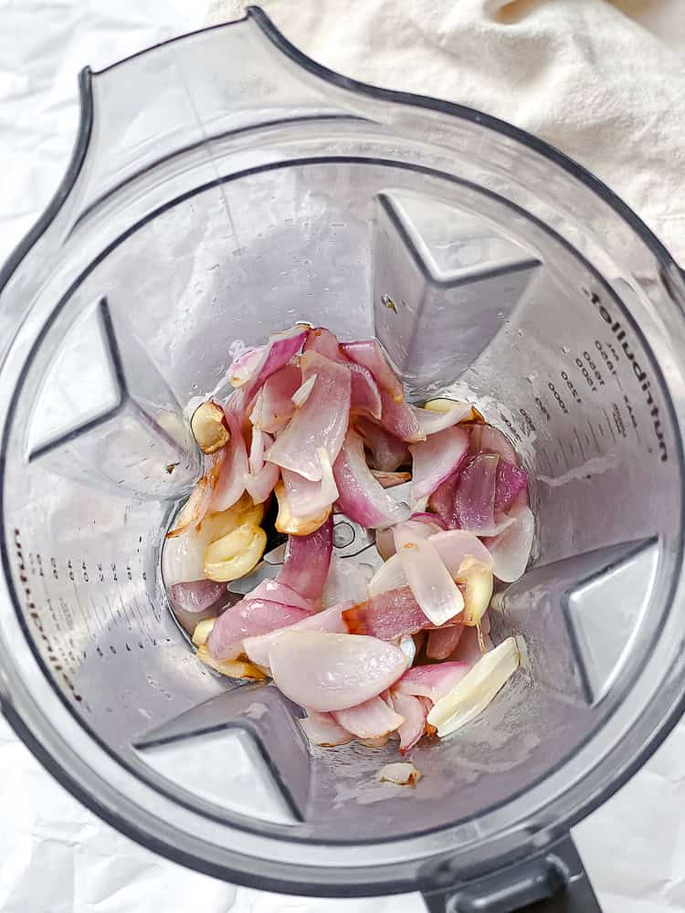 process shot showing onions and garlic in blender