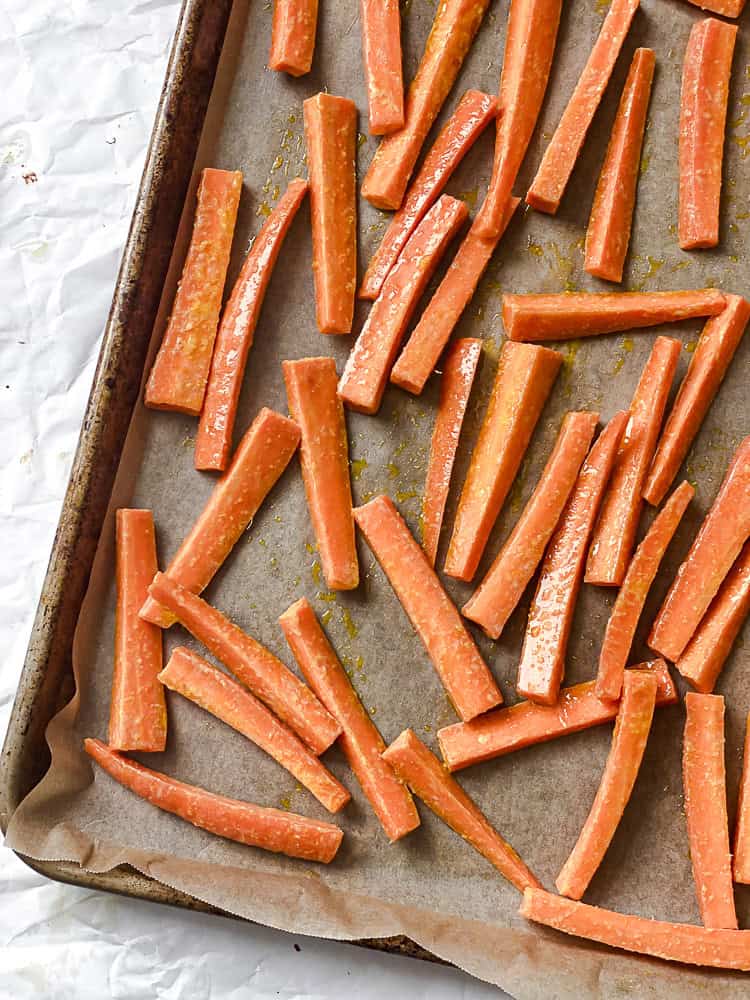 process shot showing carrot fries on a baking sheet