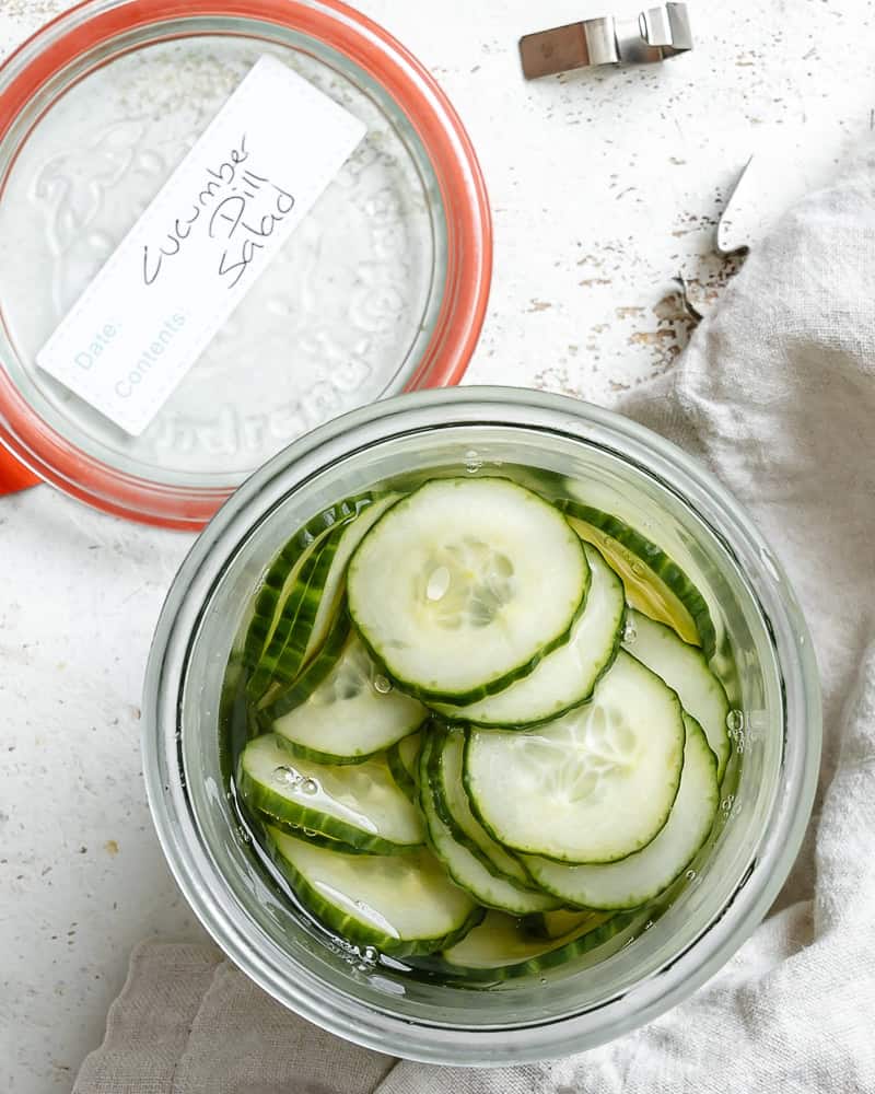 cucumber dill salad in a glass storage container.