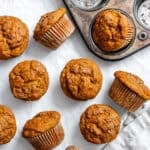 baked sweet potato muffins next to a muffin tin.