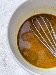 Process shot showing mixing sauce in pan.