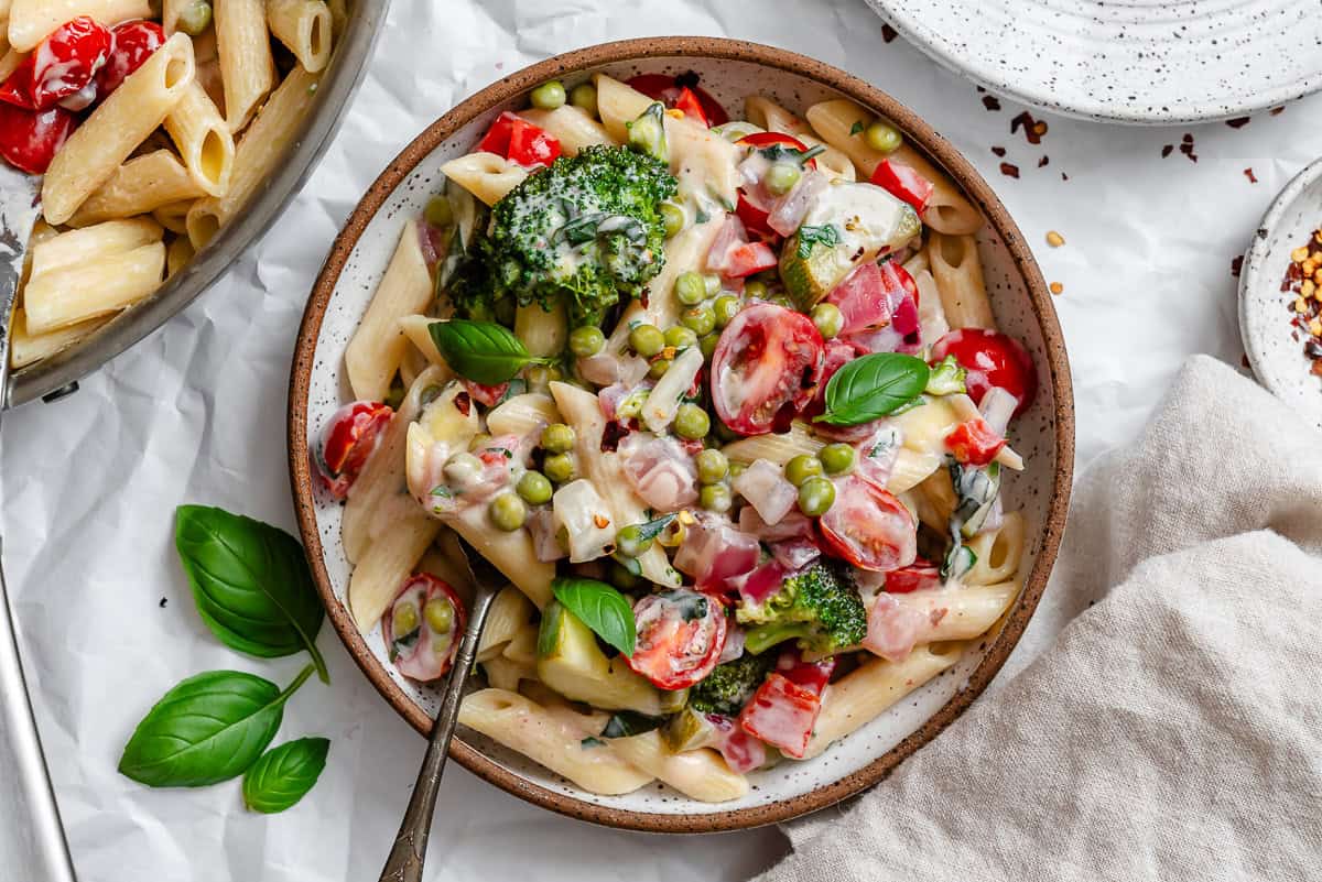 vegan pasta primavera in a white bowl.