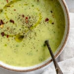 a bowl of vegan zucchini soup in a white bowl.