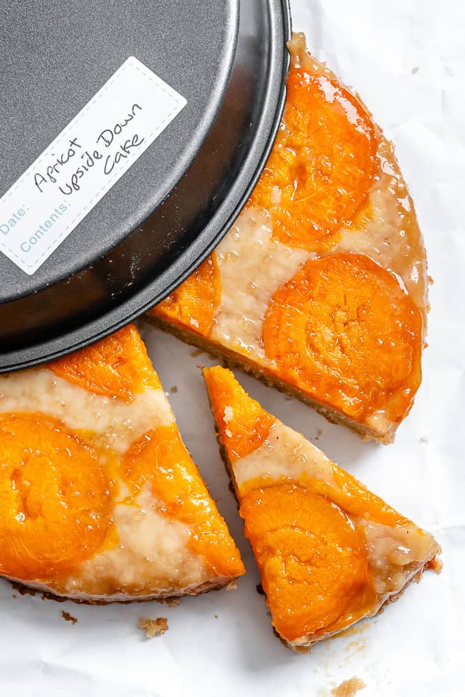 completed Apricot Upside Down Cake alongside storage container