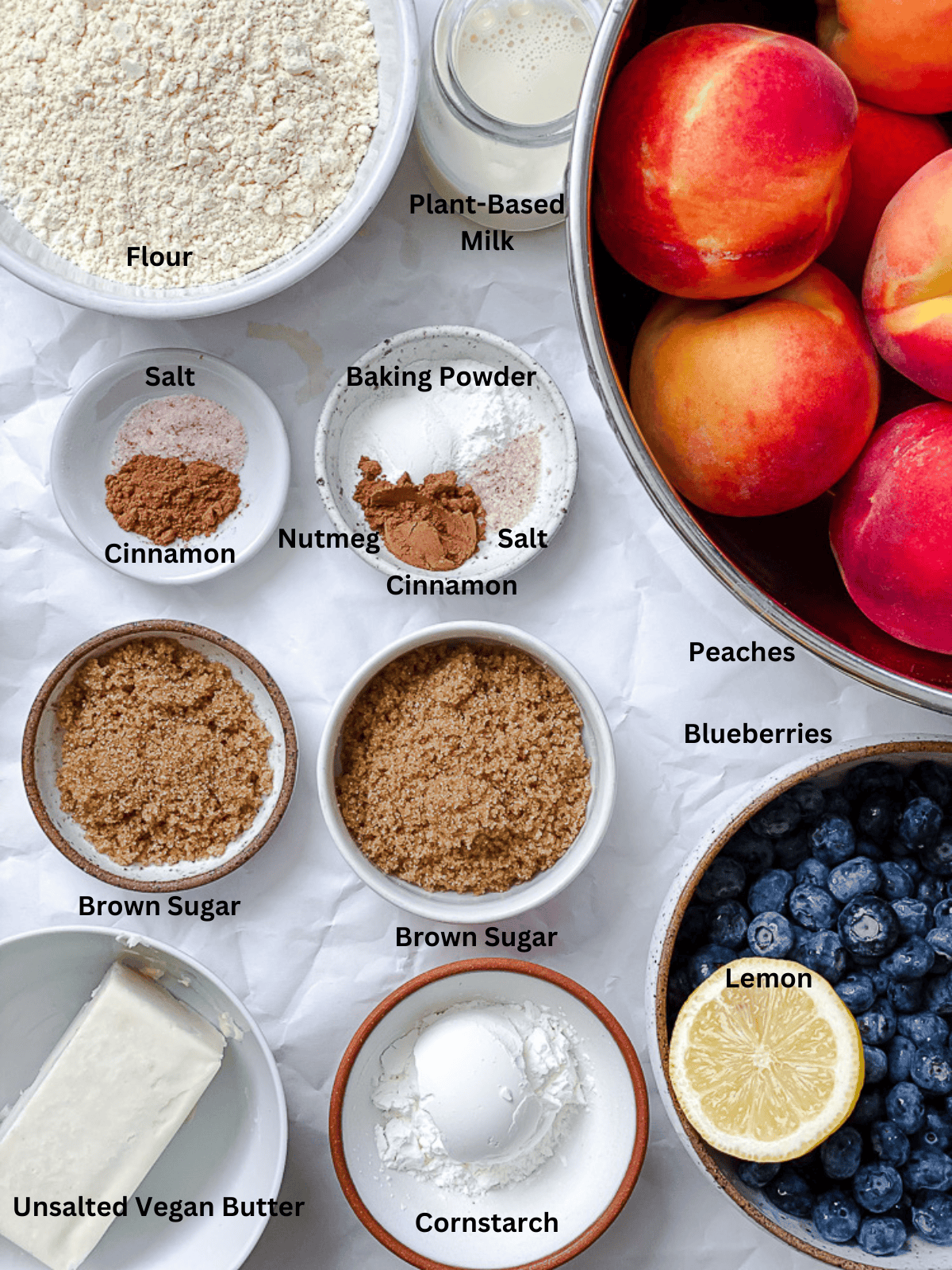 ingredients for Peach and Blueberry Cobbler on a white surface