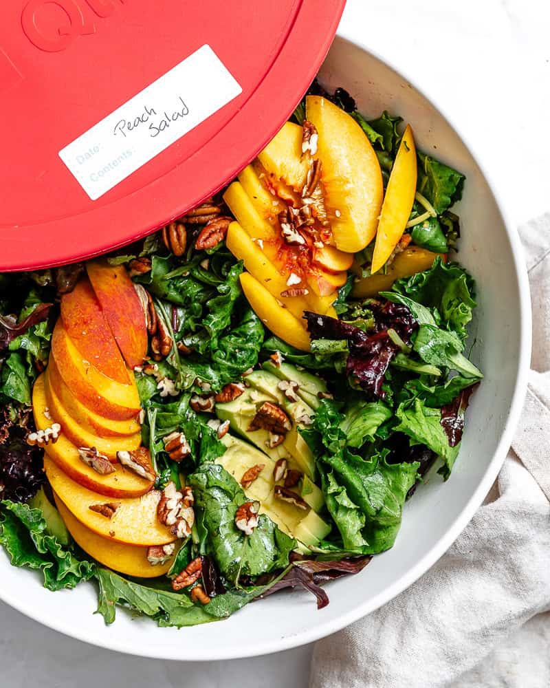 leftover peach salad in a large storage container.