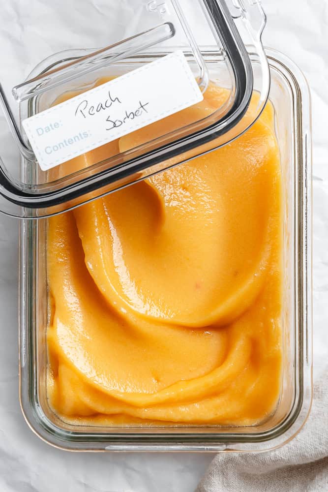 peach sorbet in a glass storage container.