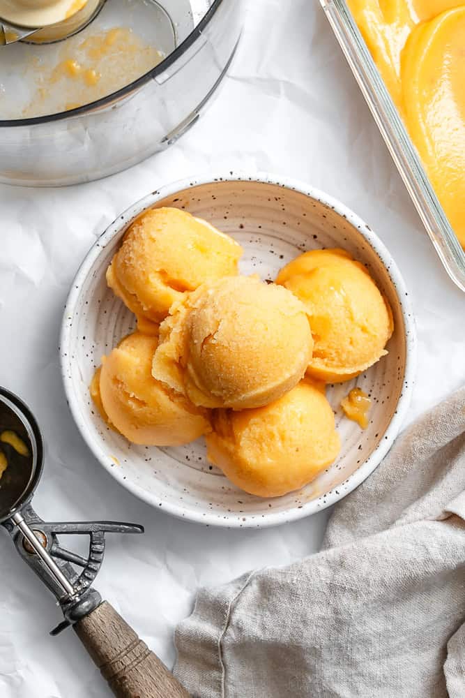 5 scoops of peach sorbet in a white bowl.