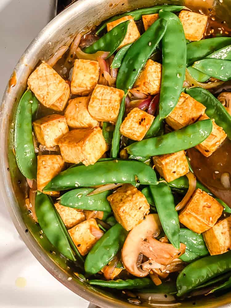 process shot showing tofu and veggies cooking in a pan