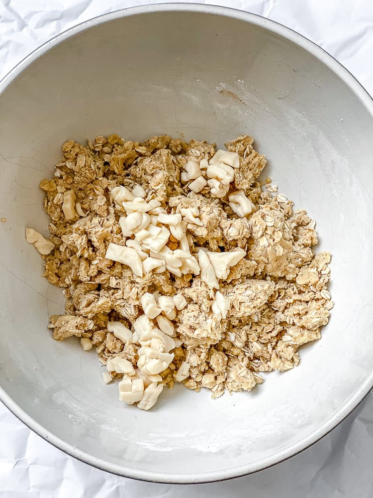 Oat streusel topping mixed in a bowl for vegan apple pie bars.