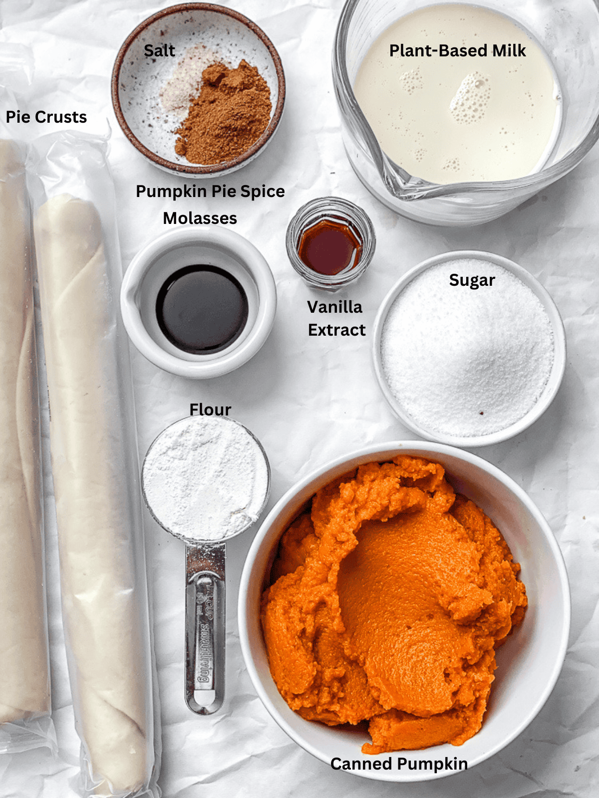 ingredients for Mini Pumpkin Pies measured out on a white surface