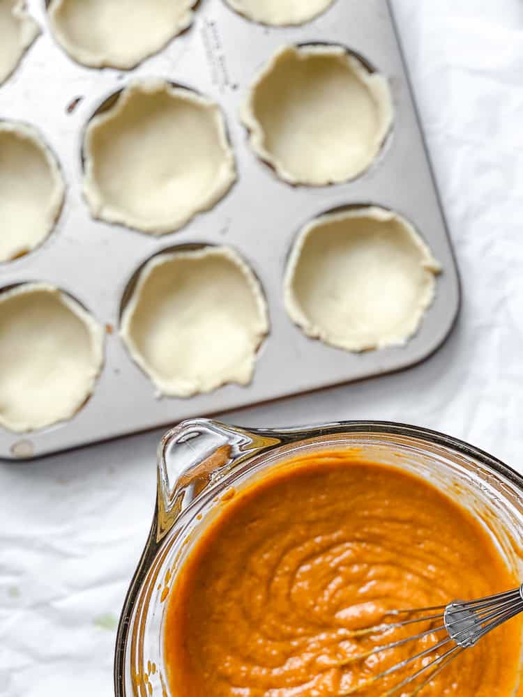 process shot showing pie crust in muffin tin